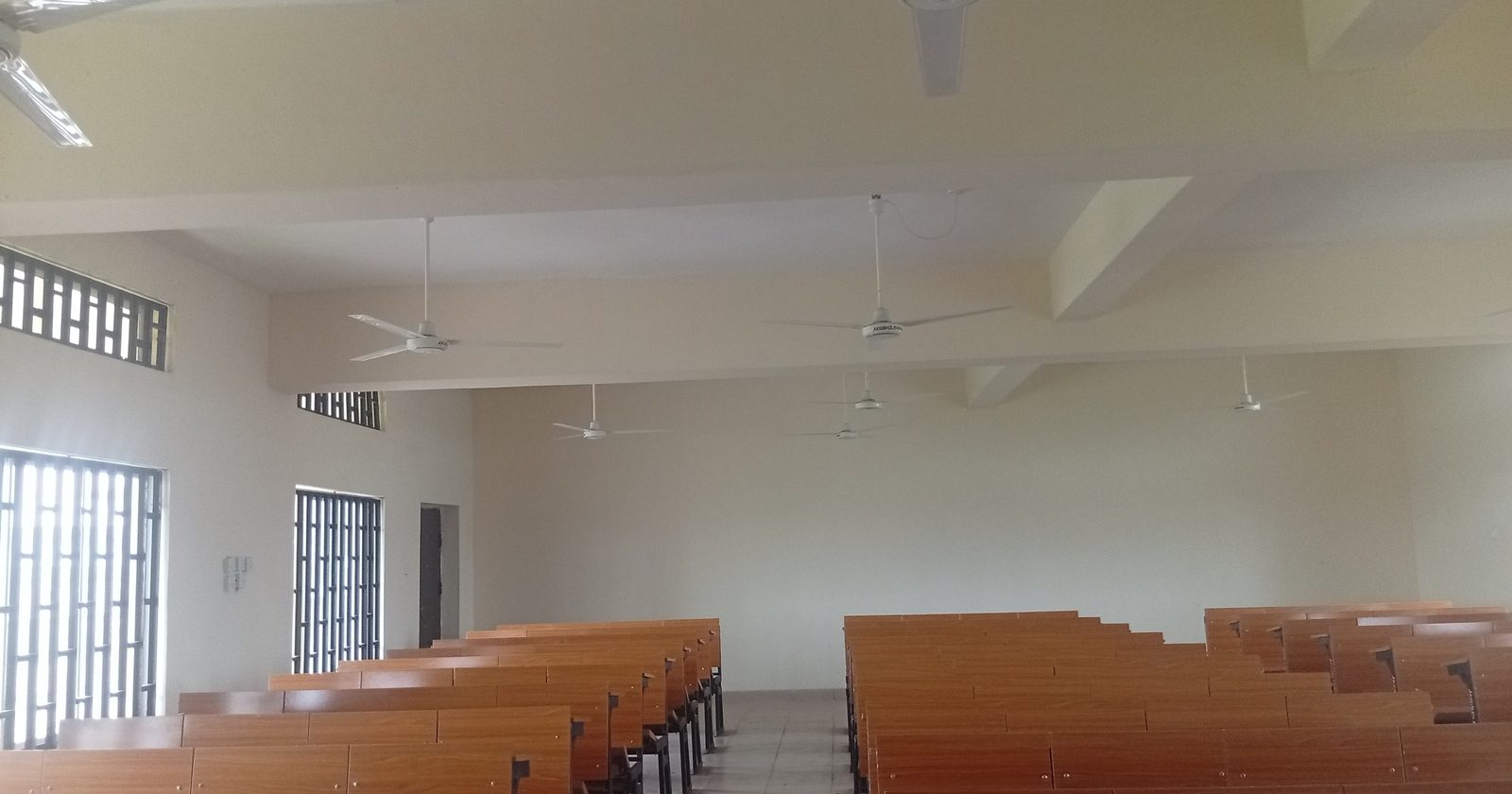Pusta sala wykładowa z rzędami drewnianych ławek
