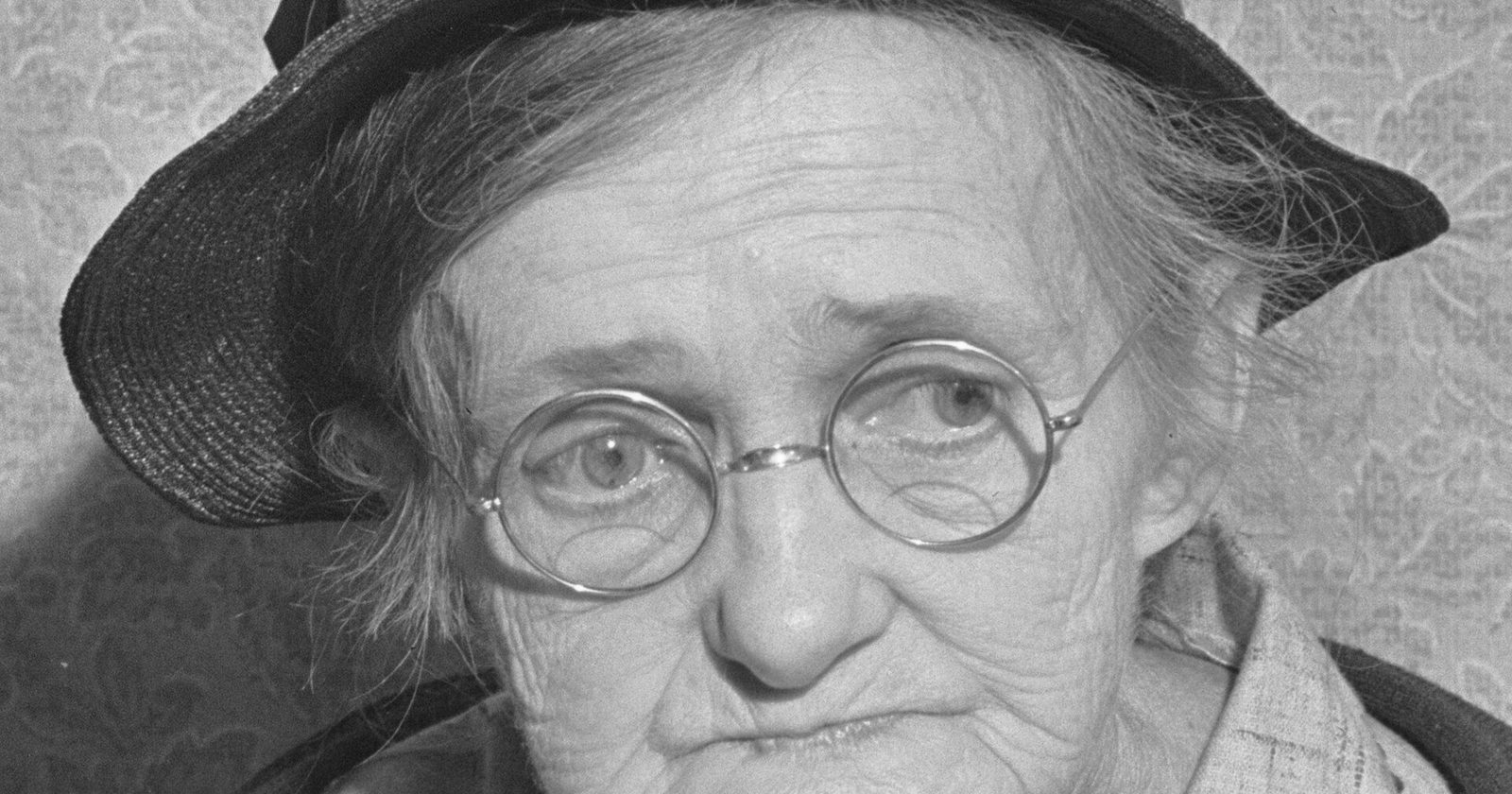 Portret starszej kobiety w kapeluszu i okrągłych okularach