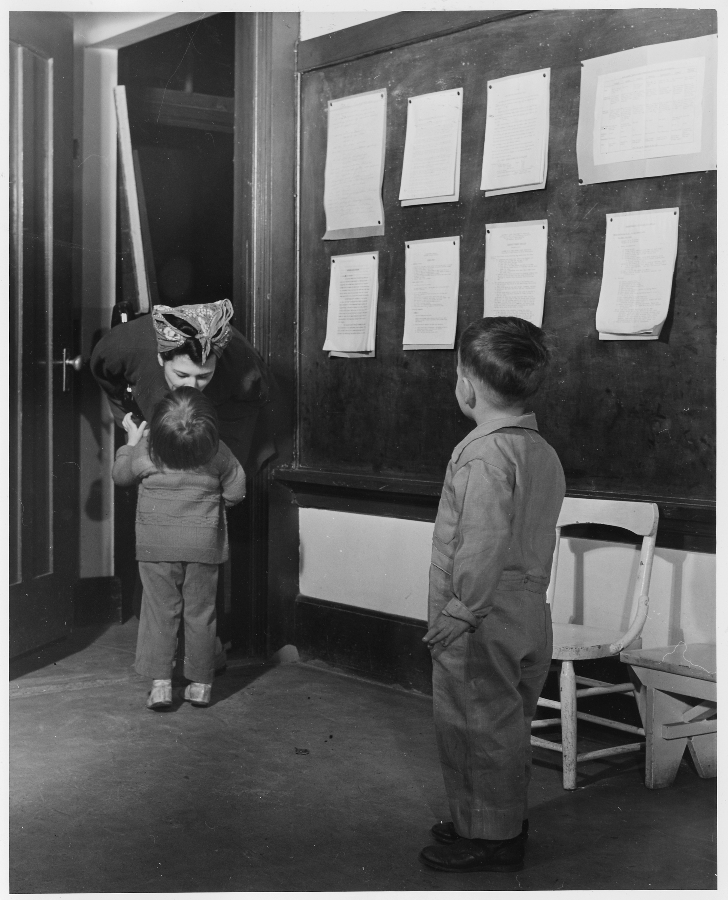 Pracująca matka odprowadza dziecko do żłobka przed zmianą w fabryce, Oakland w Kalifornii, około 1943 roku — fotografia z zasobów amerykańskich Archiwów Narodowych