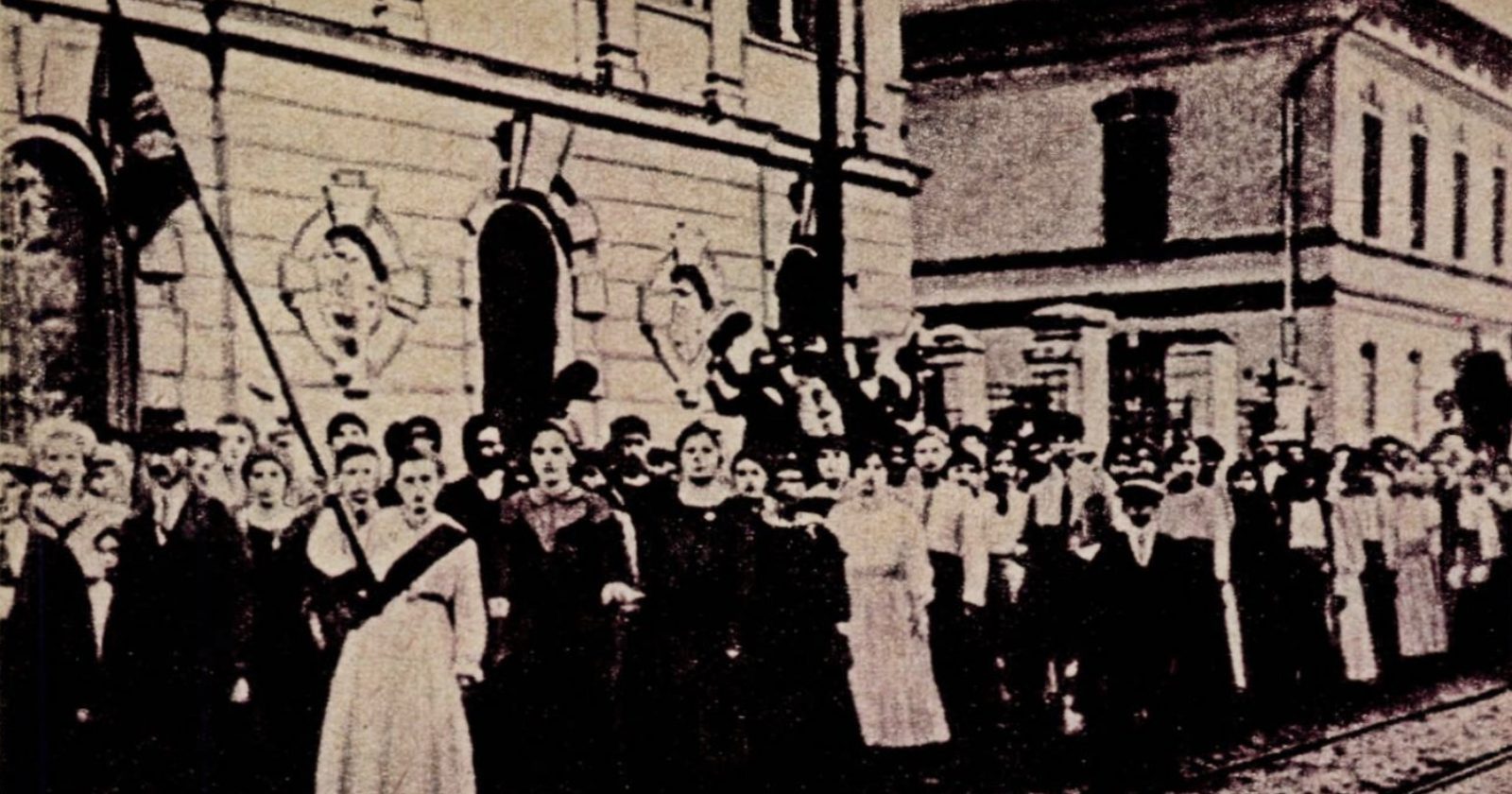 Archiwalne zdjęcie z 1914 r.: pracownice fabryki z transparentem na miejskiej ulicy